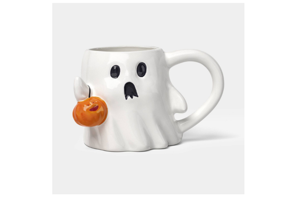 White ghost-shaped stoneware mug holding a small orange pumpkin