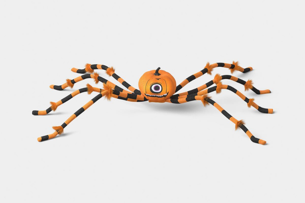 Pumpkin-head spider prop with orange and black legs