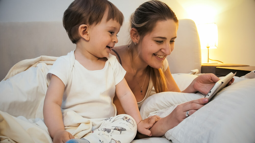 A woman and her son smiling while checking a mobile phone. You can check on a definitive list of 7 co-parenting boundaries you need to know.