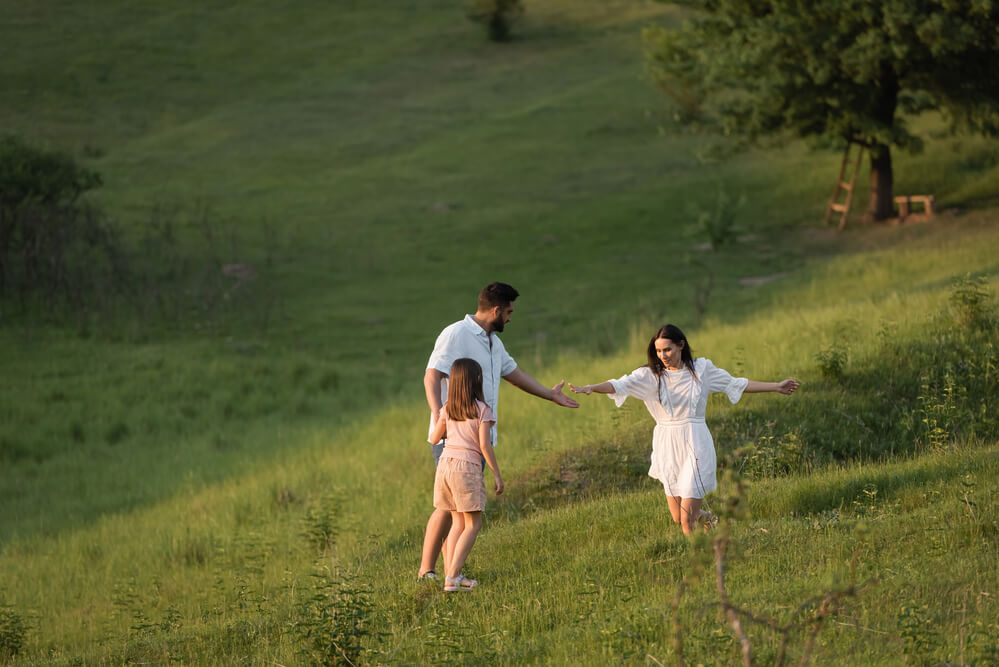 A family out in the field, holding hands. This is a definitive list of 7 co-parenting boundaries you need to know.