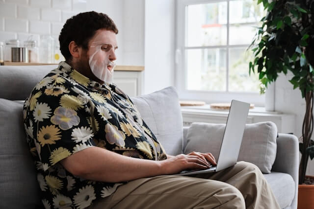 person in face mask on computer