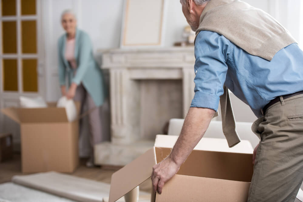 A senior couple packs and moves boxes from their home in an article about free movers and free moving help.