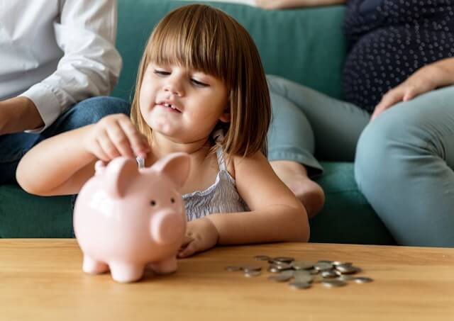 toddler with piggy bank