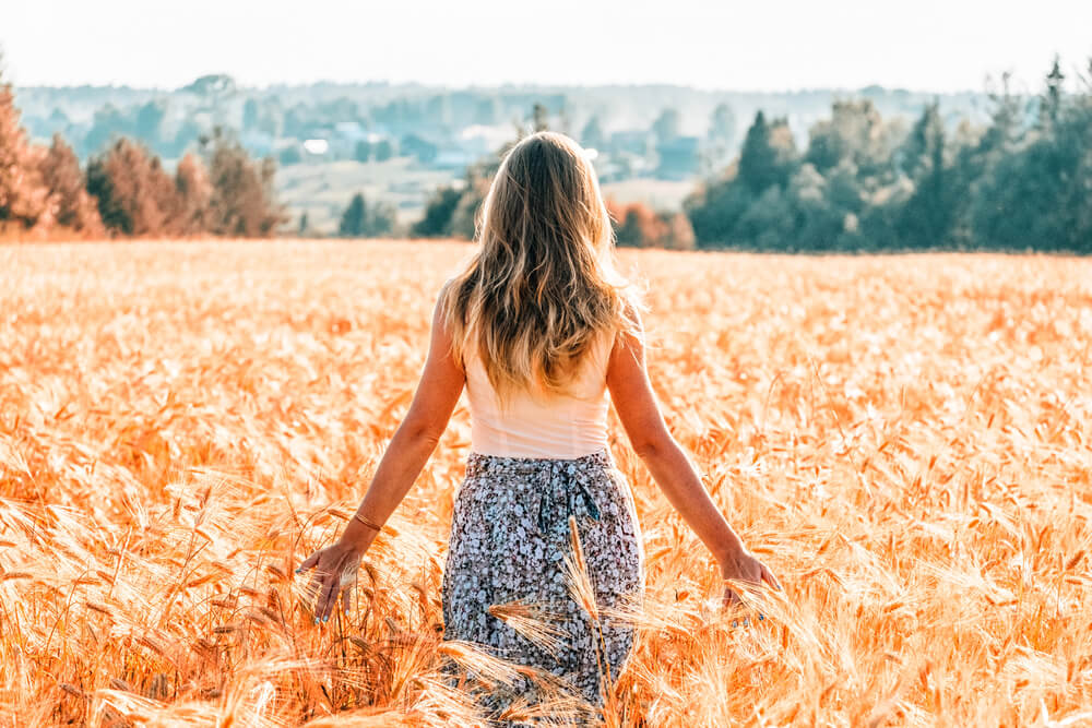 A woman facing away in a field. Tips on dating a widower: 6 things you need to know. Find them all here.