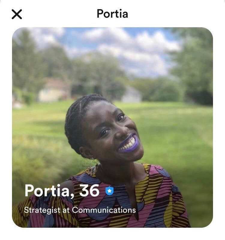 This is a photo of a smiling woman with purple lipstick in an online dating profile.