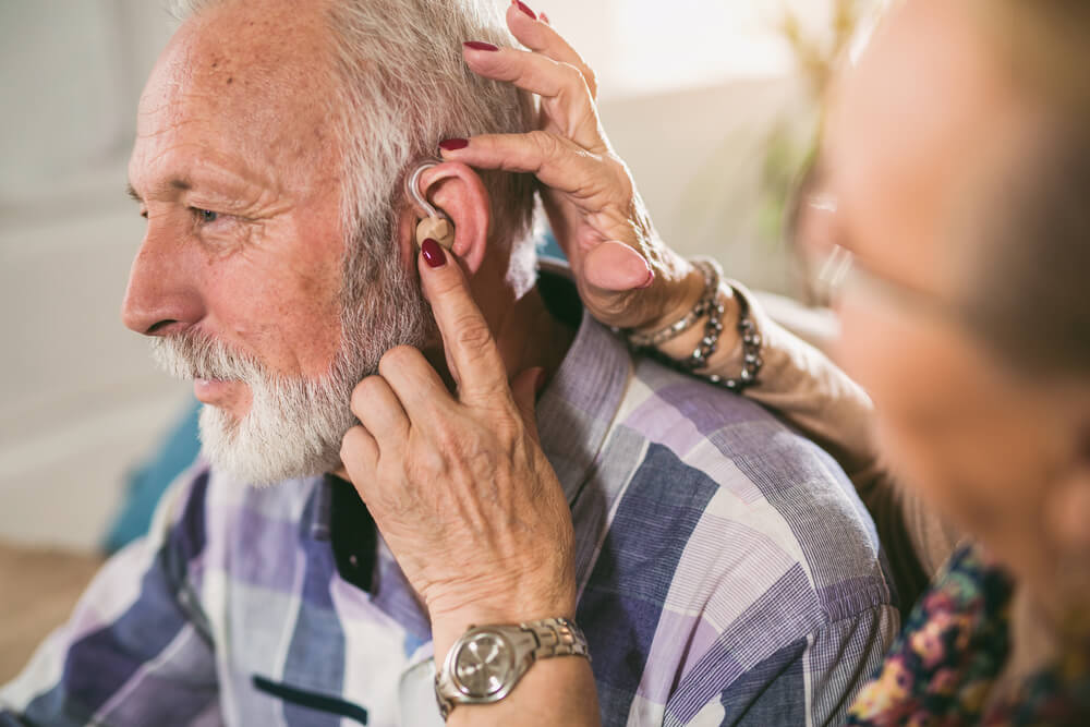Man tries on free hearing aids for seniors.