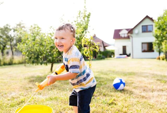 Child playing in front yard of house