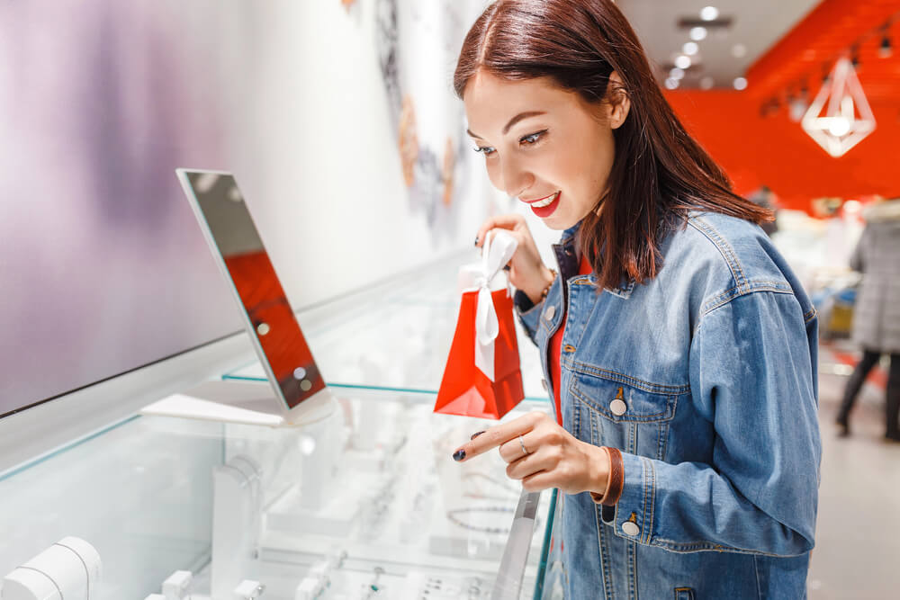 A woman buying jewelry. Check out this guide to selling jewelry for cash (+ negotiation tips).
