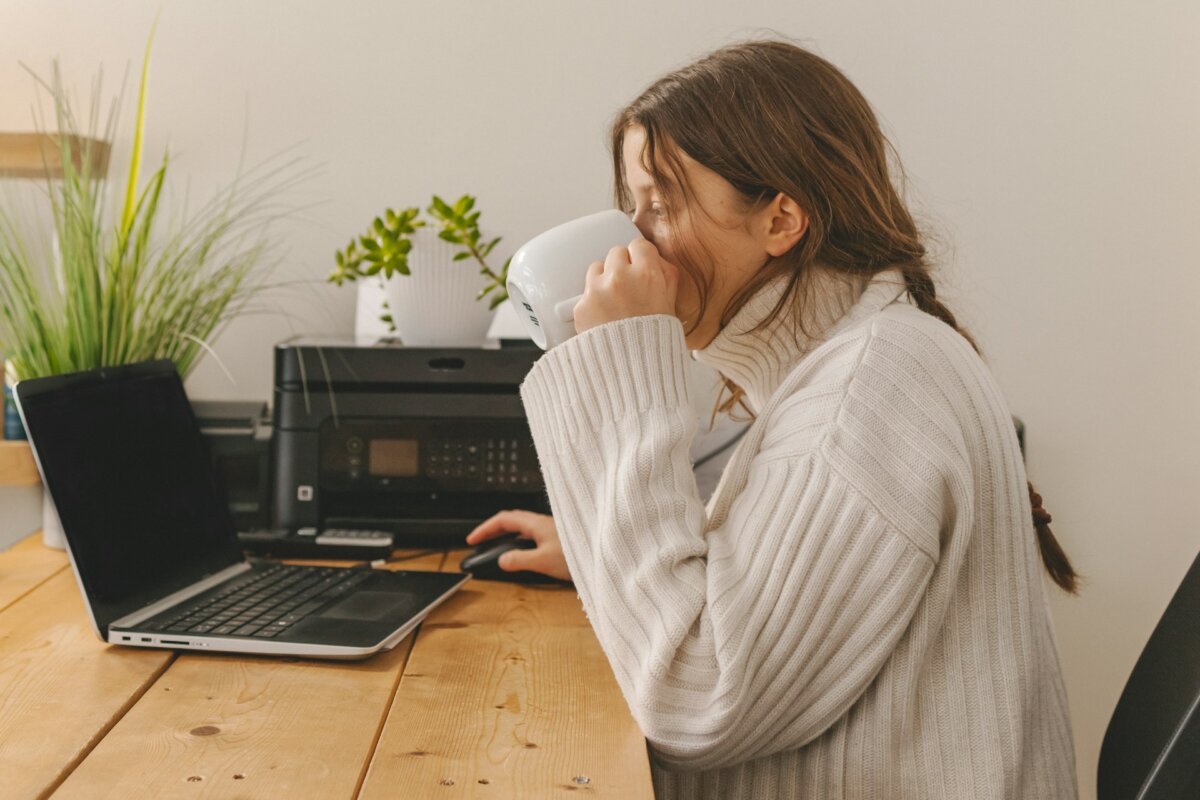 person drinking coffee working at computer
