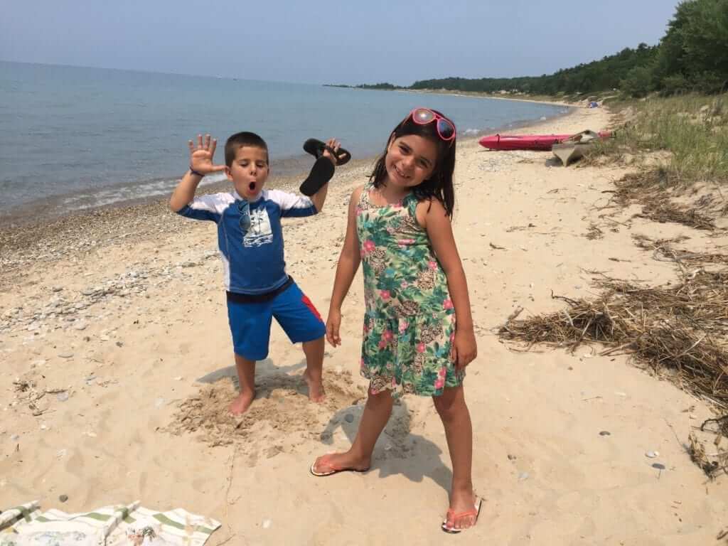 Emma's kids on beach near Home Exchange stay in Charlevoix, Michigan..