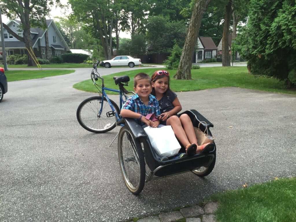 Emma's kids in a bike bucket at Home Exchange stay in Charlevoix, Michigan.