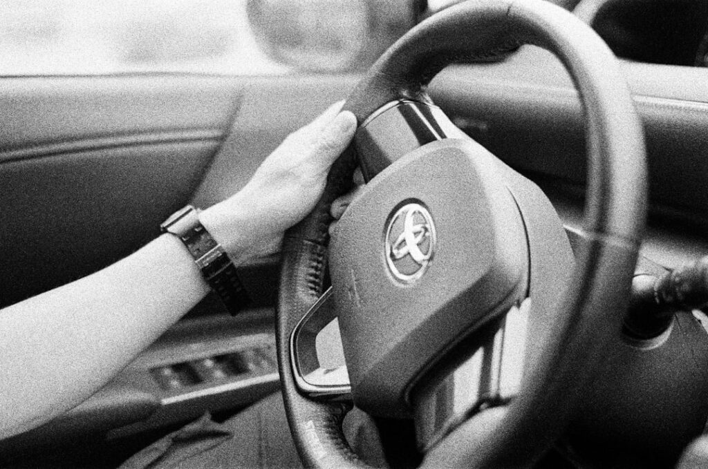 close up of hands on a steering wheel