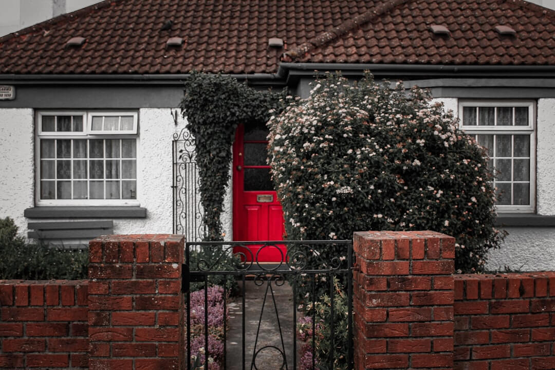a house with a red door and a fence