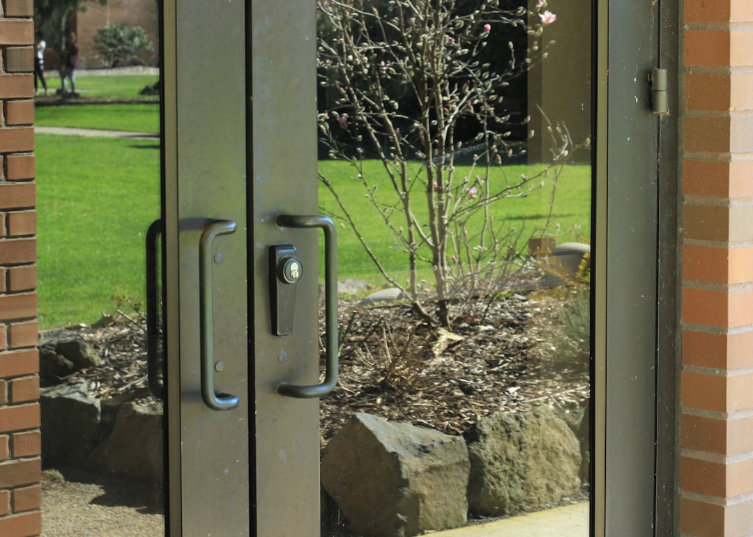 Reflections of trees and grass in glass doors.