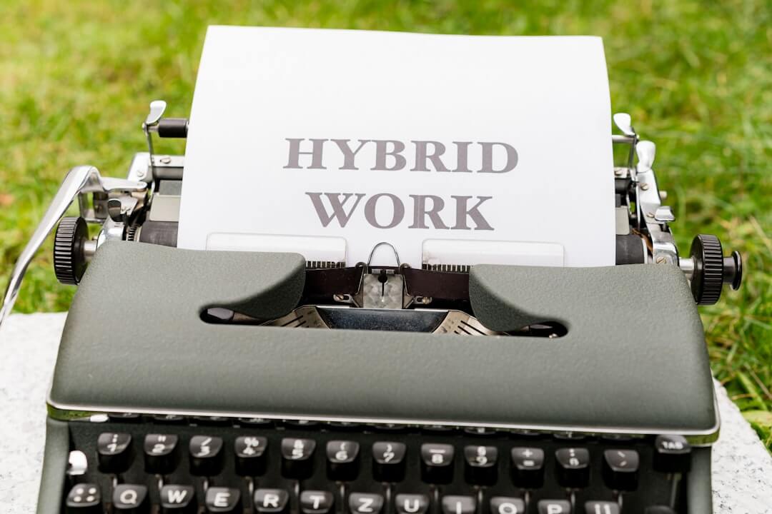 a typewriter with a sheet of paper that reads hybrid work