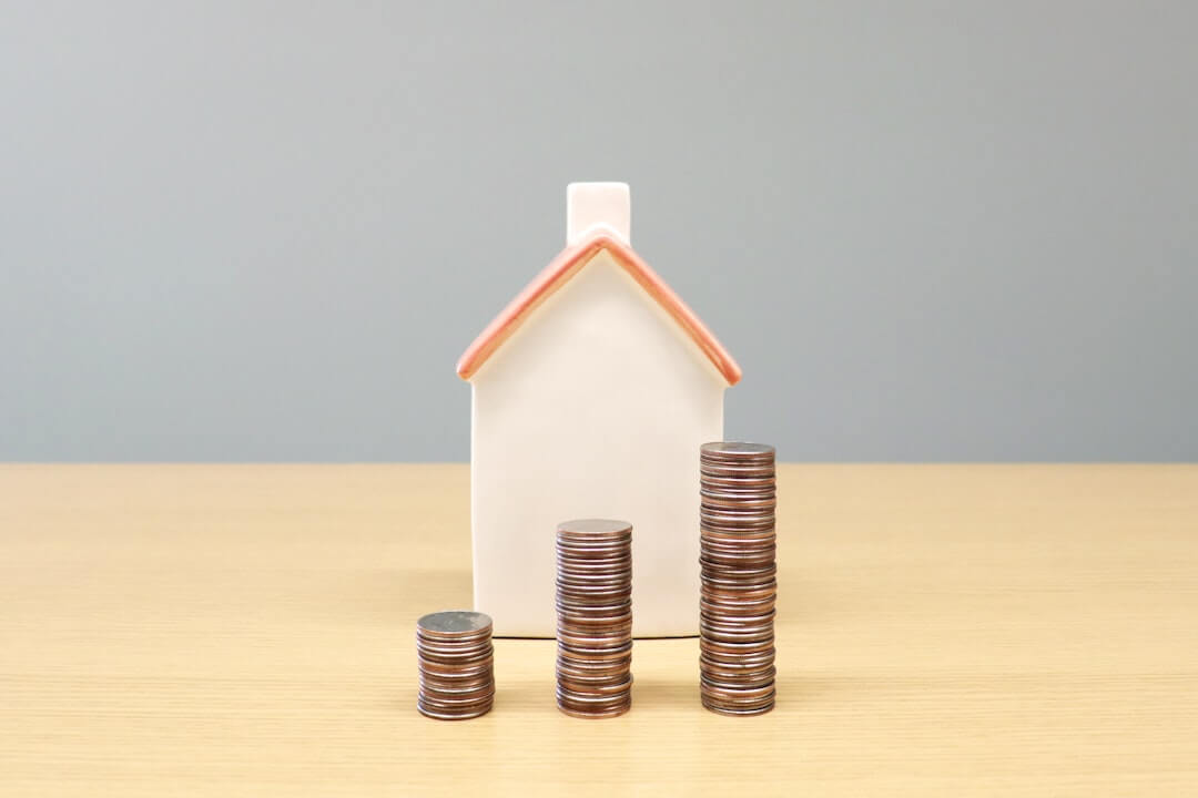 a house and stacks of coins on a table