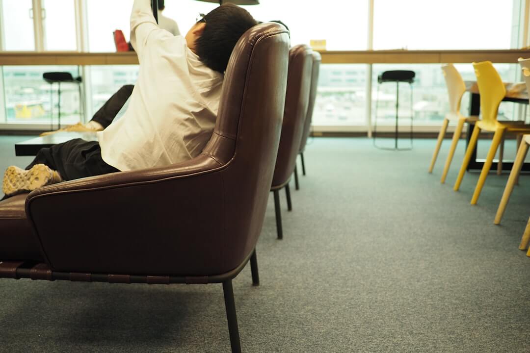 A man sitting in a chair with a laptop on his lap