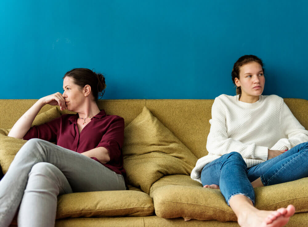 teen sitting away from mother on couch
