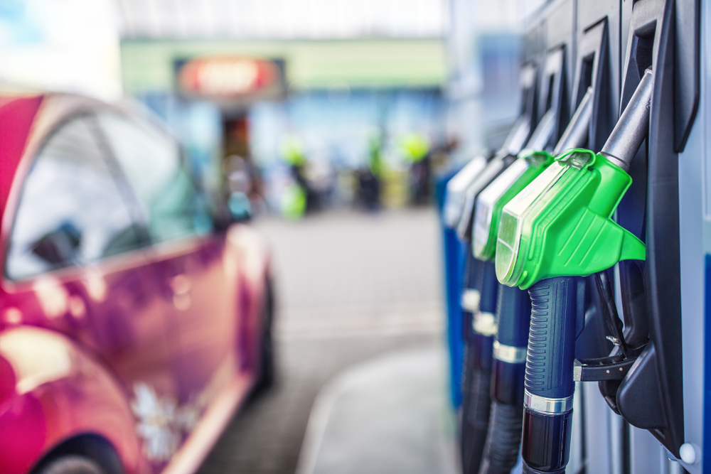 Row of fuel pump nozzles beside a car at a filling station