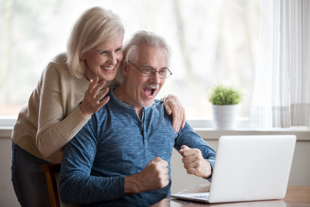 happy pensioners looking at computer