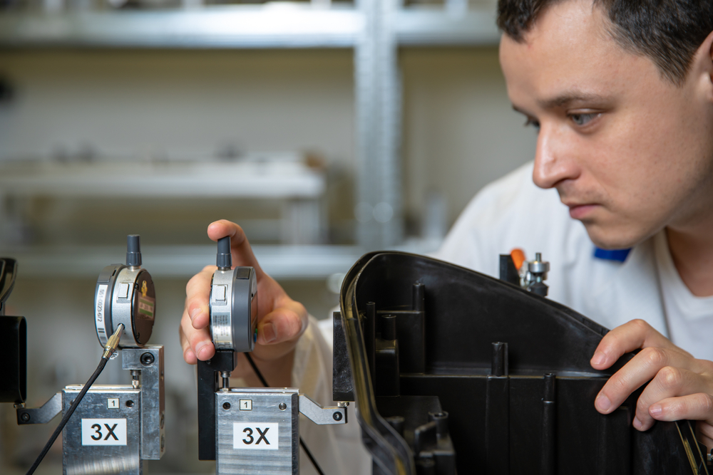 Calibration technician checking dial gauges in measurement laboratory Calibration technician checking dial gauges on a precision measurement apparatus in a laboratory