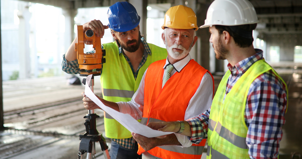 older surveyor working on building site