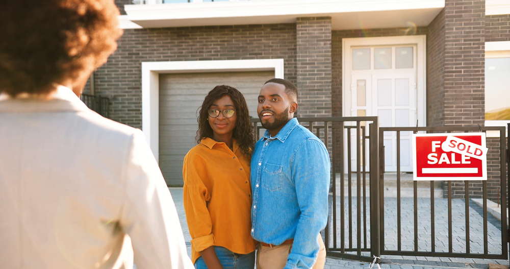 couple standing outside a sold house