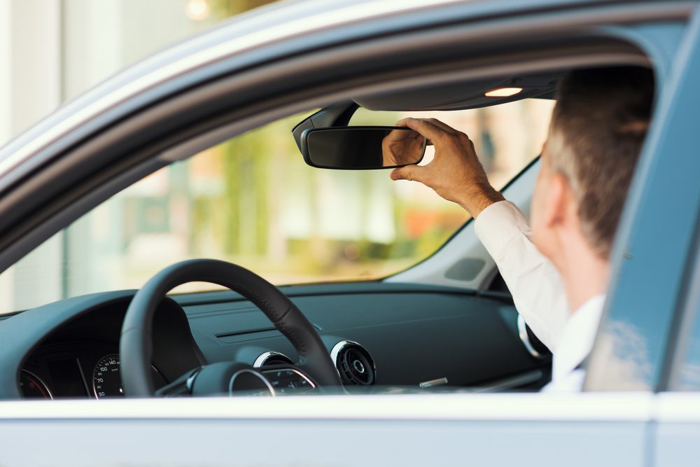 Man adjusting the rearview mirror before driving
