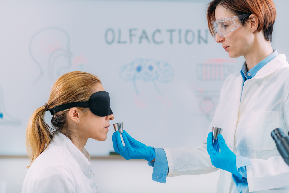 Blindfolded participant smelling a sample during a laboratory sensory test