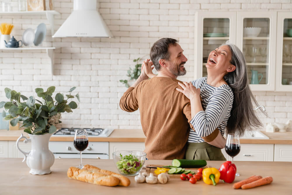 couple cooking and dancing together at home