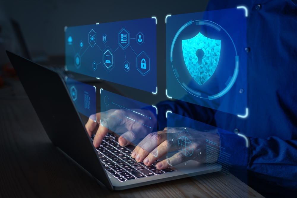 Person using a laptop with network diagrams, padlocks and a digital security shield
