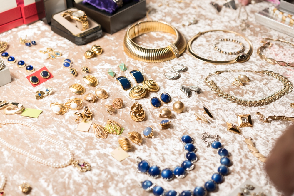 Assorted vintage earrings, necklaces, bracelets and rings displayed on a table
