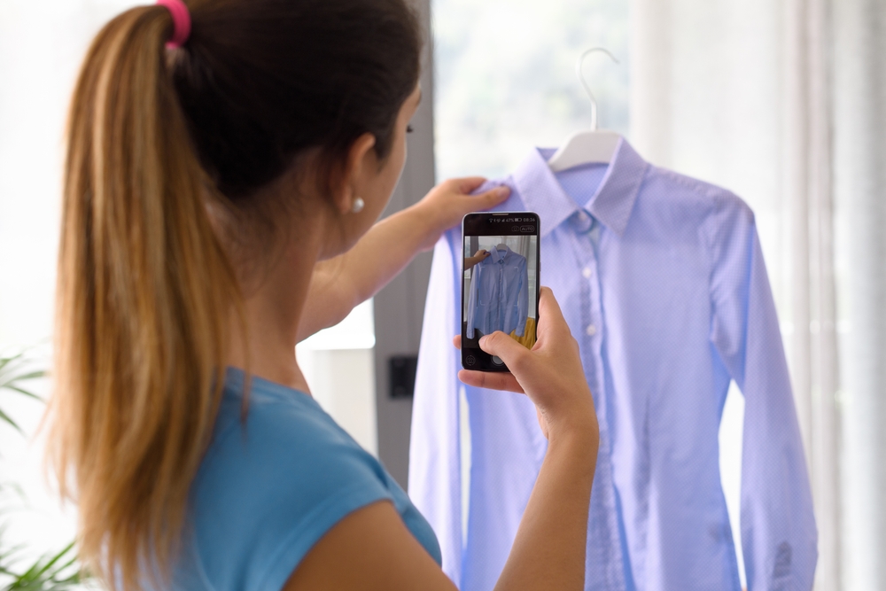 woman taking photo of a shirt to sell online