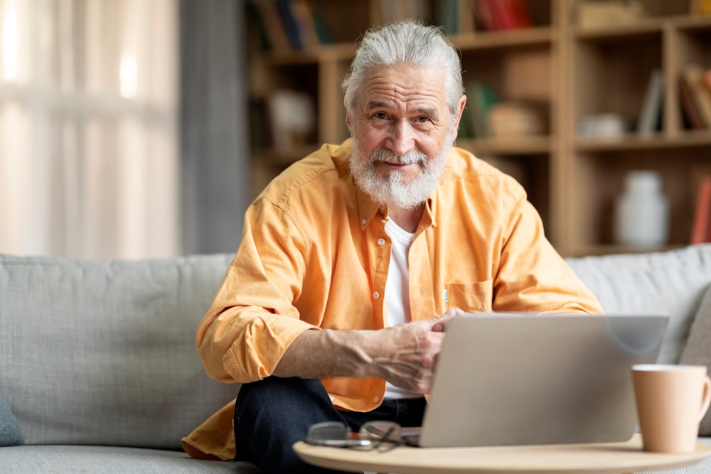 Older man using a laptop at home