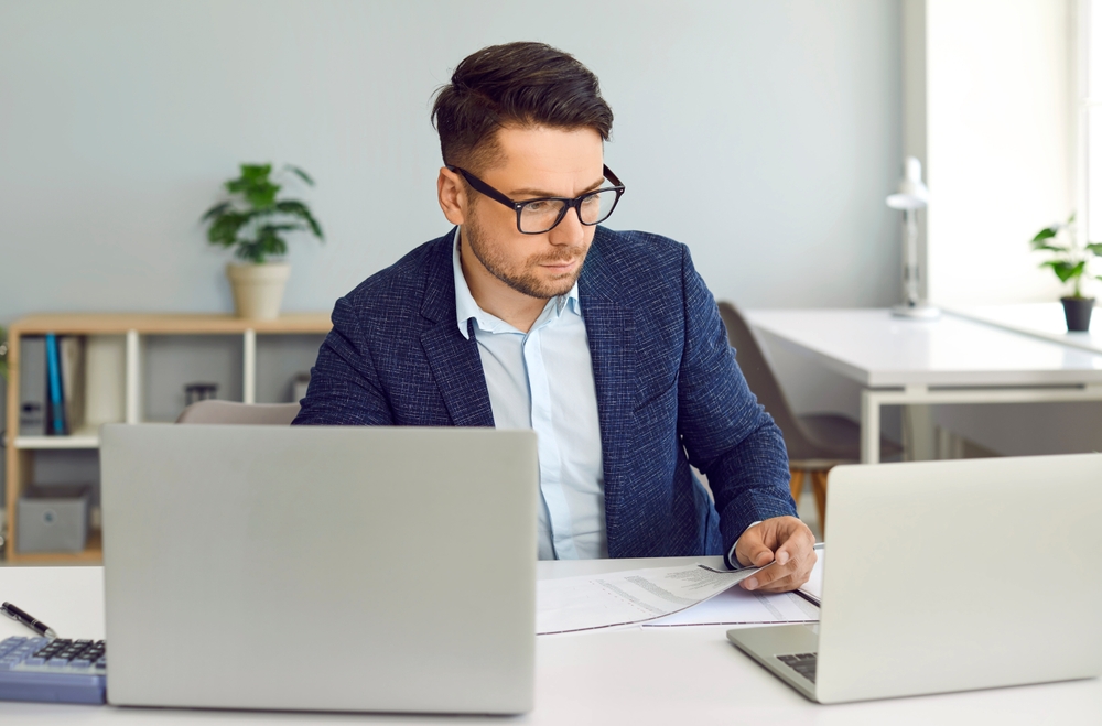 person working on two computers