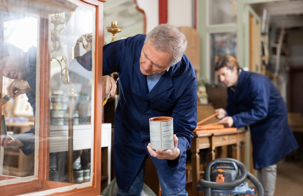 older male painting furniture