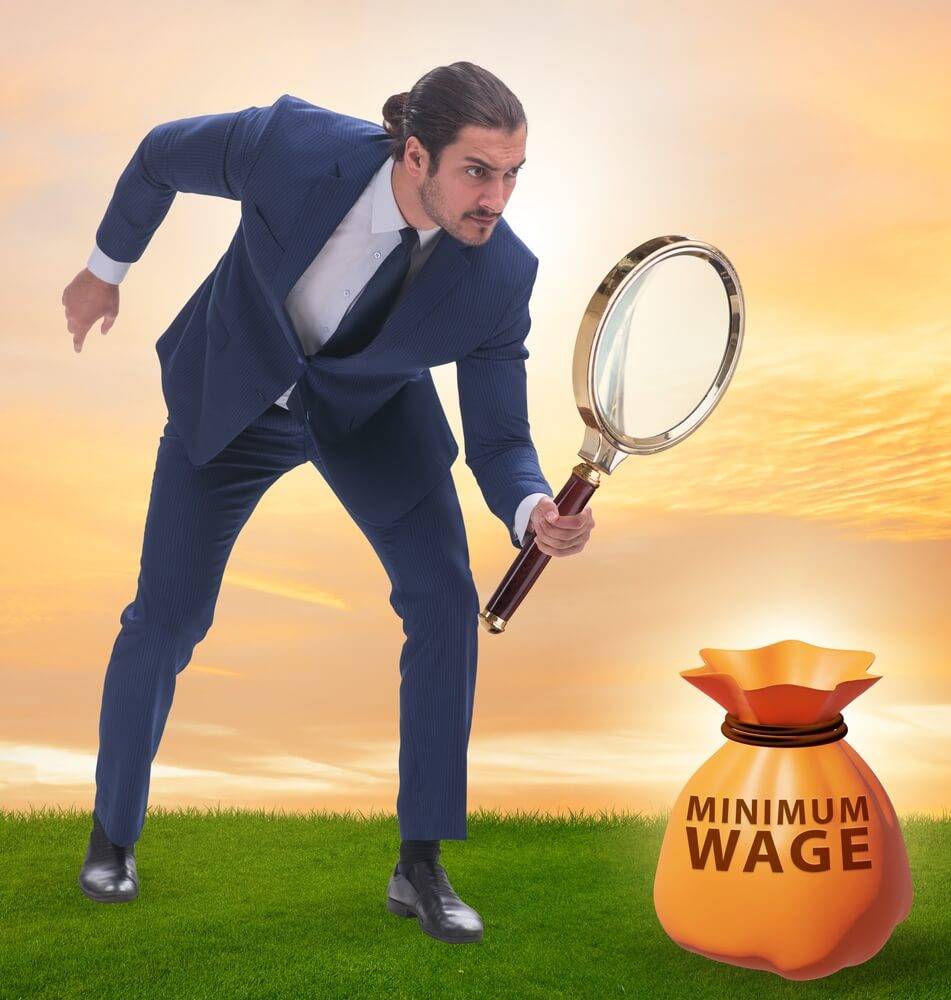 Concept of minimum wage with businessman looking at minimum wage