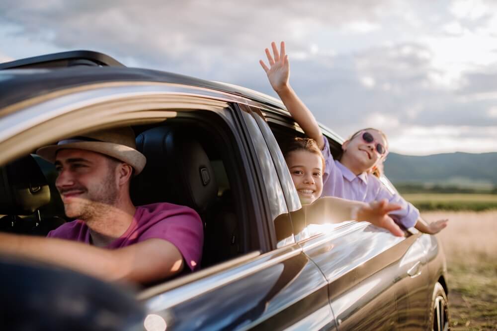 happy family driving in a car