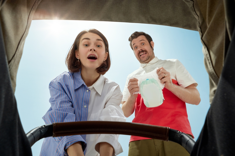 couple changing a nappy on a baby
