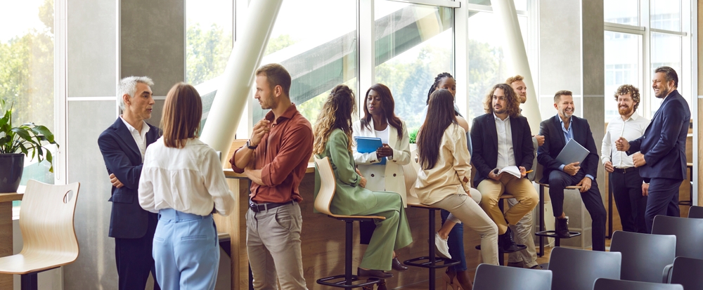 Groups of professionals talking together with notebooks and folders at a business networking event