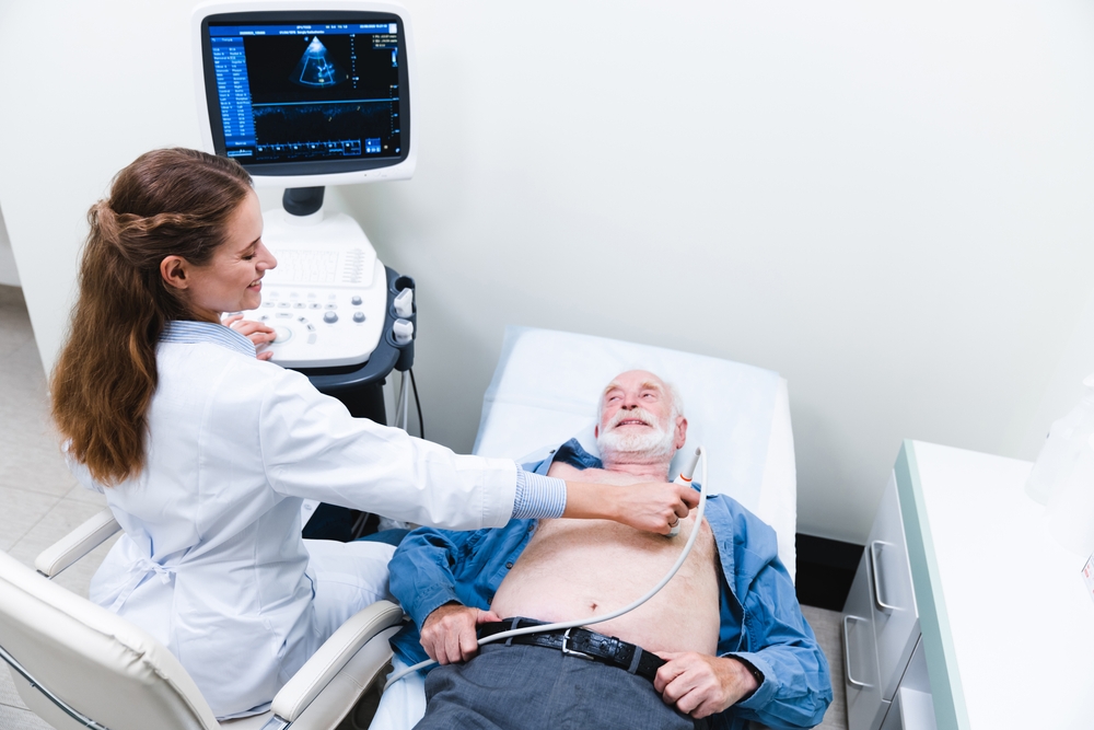 Clinician performing a heart ultrasound scan on an older patient