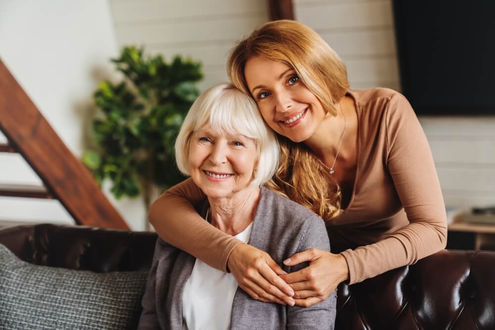 Middle-aged woman comforting elderly parent