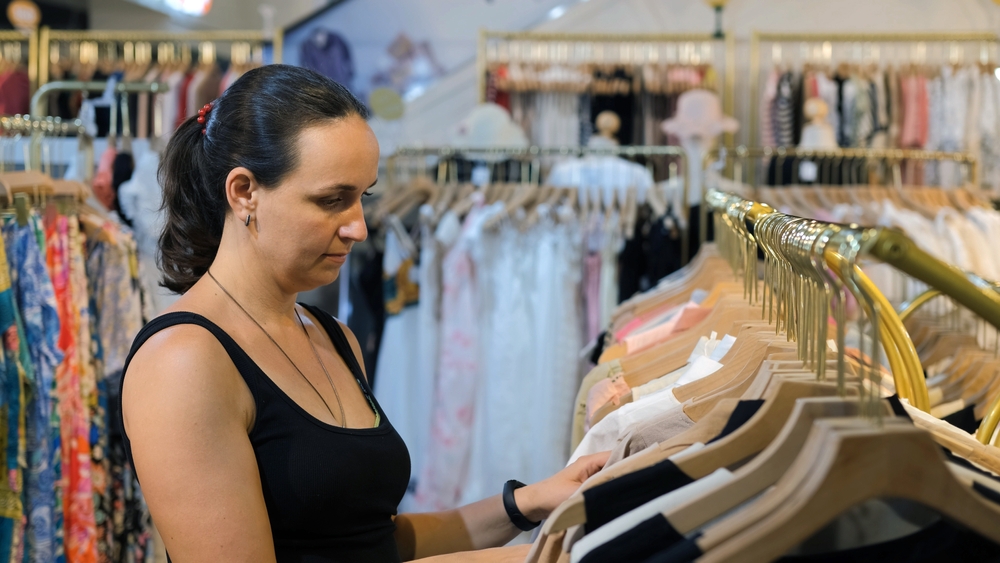 looking through clothing at a thrift store