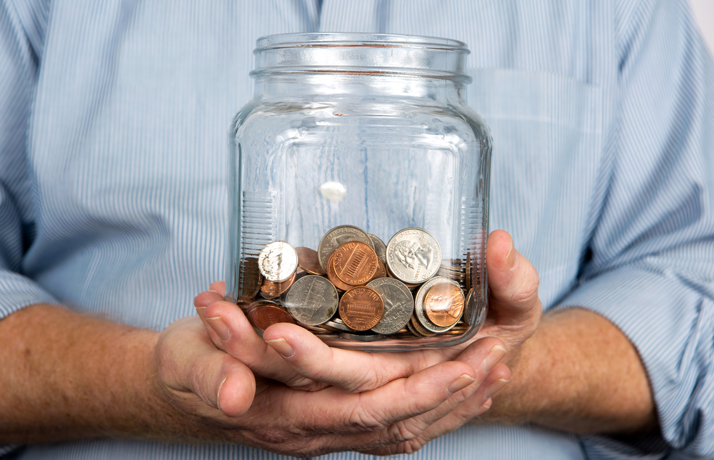 man holding a change jar