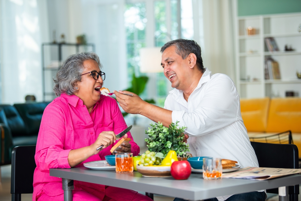 older happy couple having a lovely meal at home