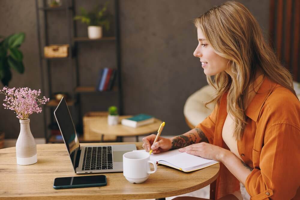 woman taking notes from a computer