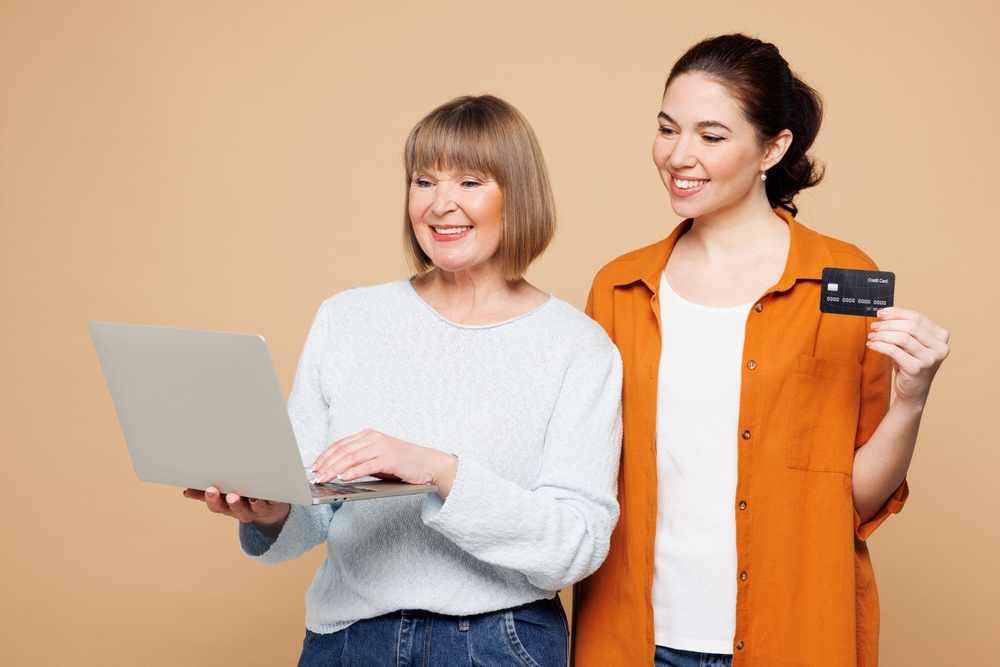 elderly parent and daughter paying with credit cards