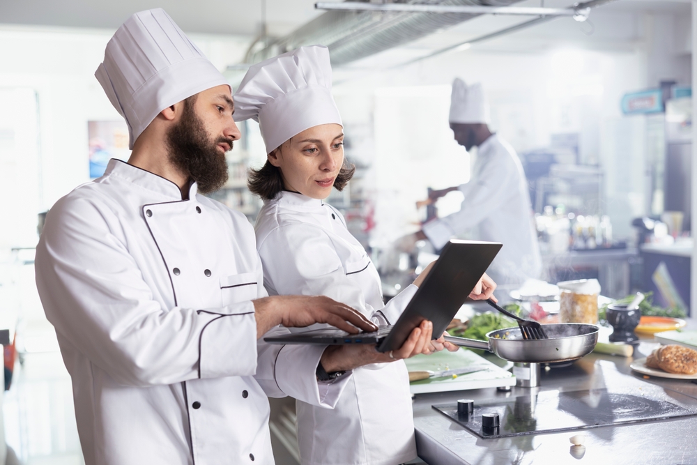 chef in restaurant working with another chef