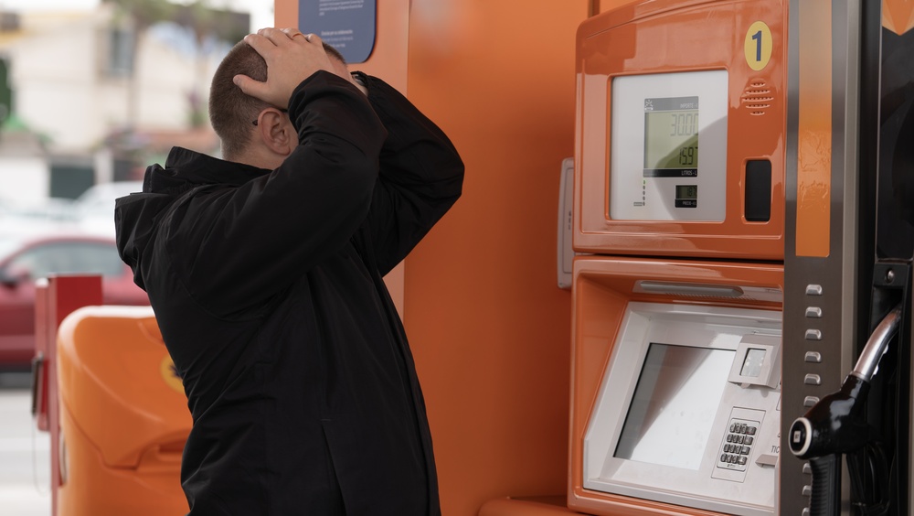 Man holding his head in his hands at gas prices