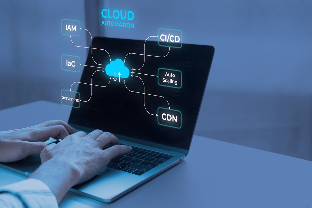 Hands typing on a laptop with a cloud automation network diagram